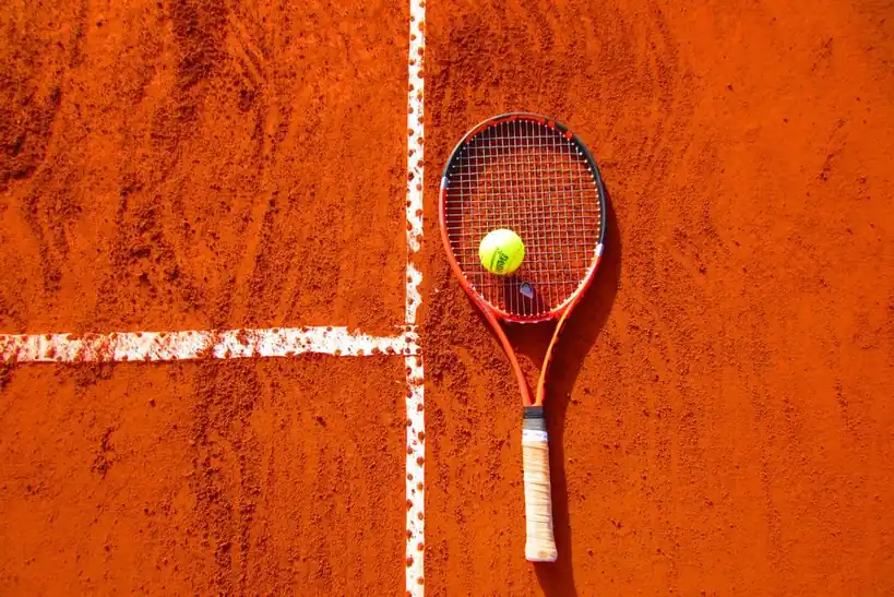 Tennis racket and ball resting gracefully along the court line